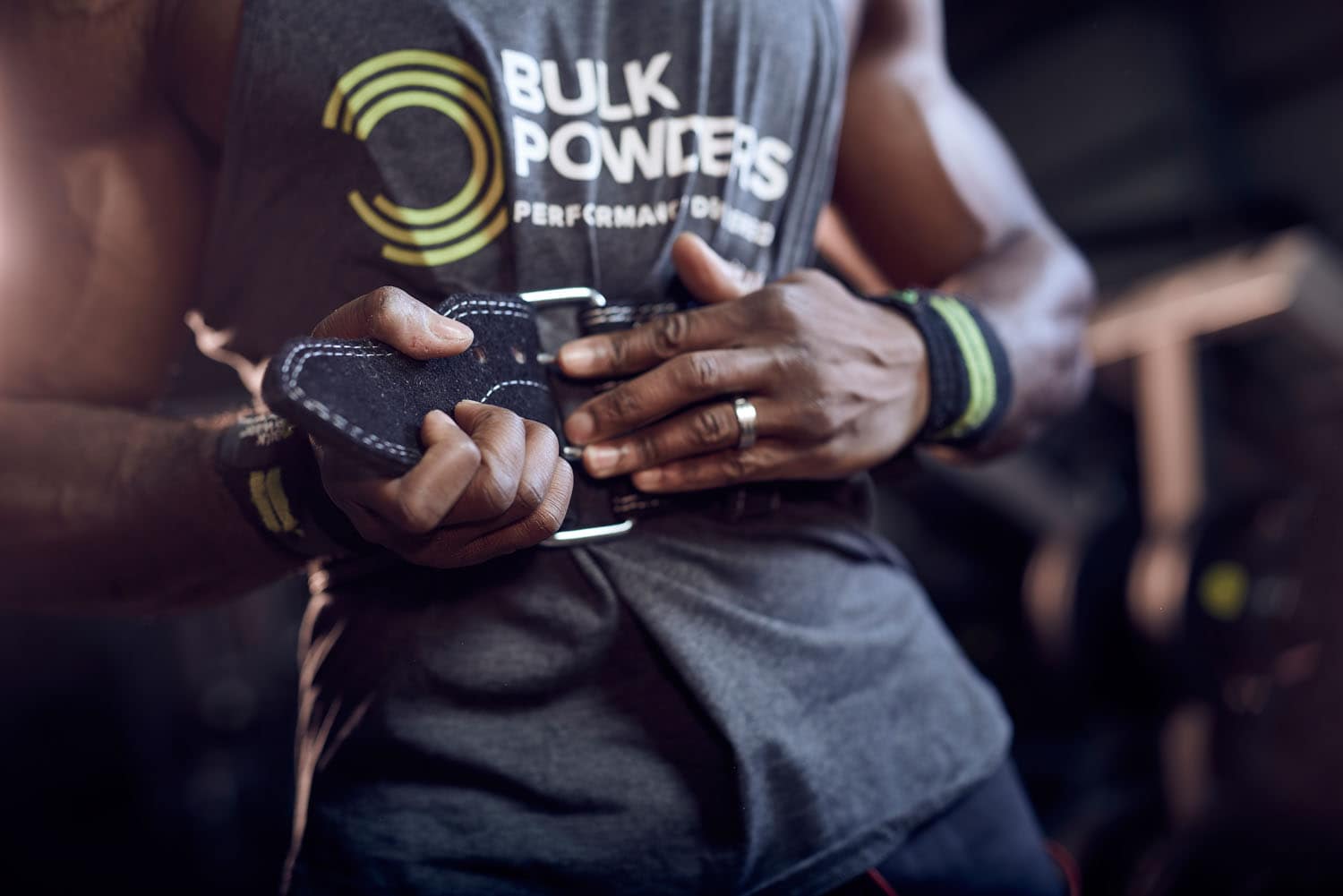 Cinematic, dark and moody image of an athlete doing an overhead press in the gym
