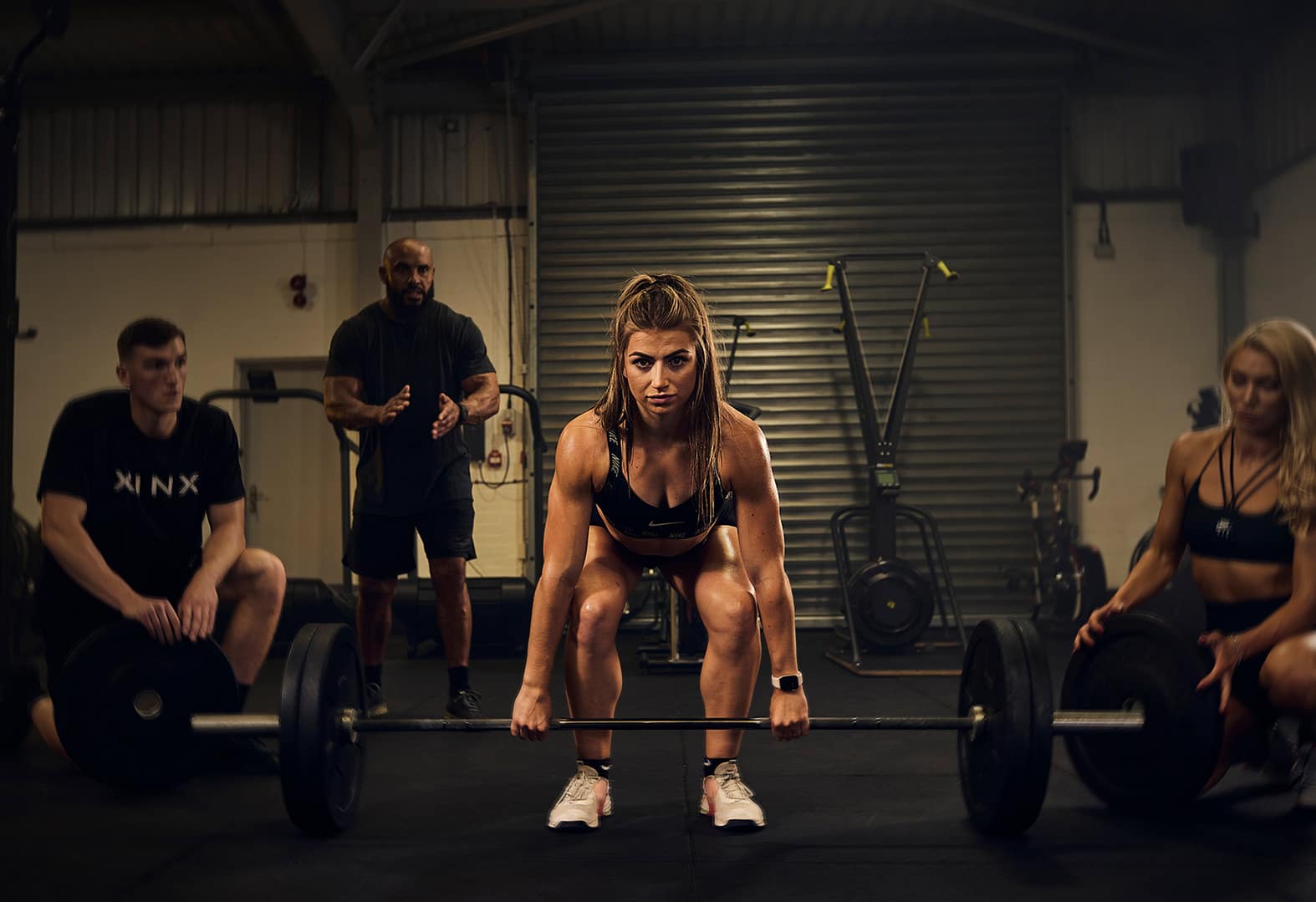 A girl preparing to lift a barbell in a gym