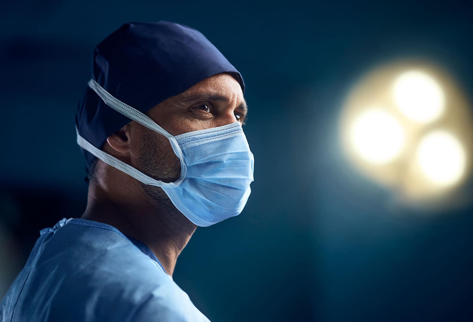 A female surgeon wearing scrubs in an operating theatre