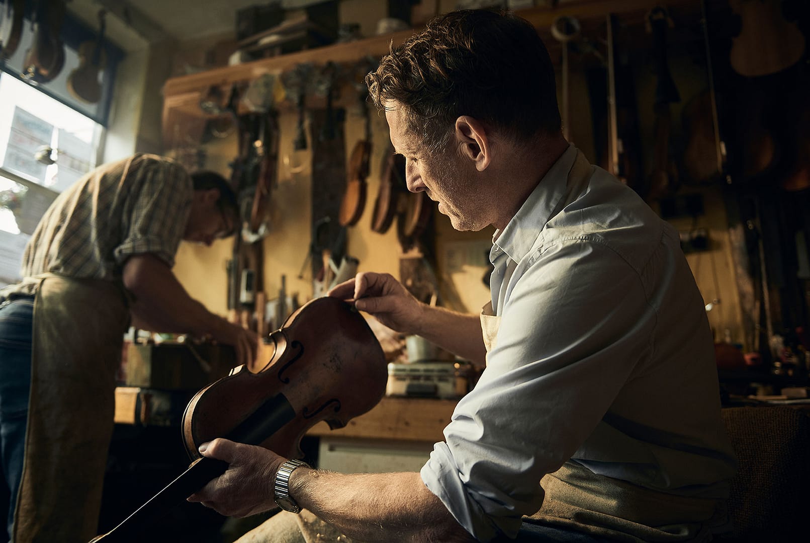Portrait of a luthier in a violin repair shop