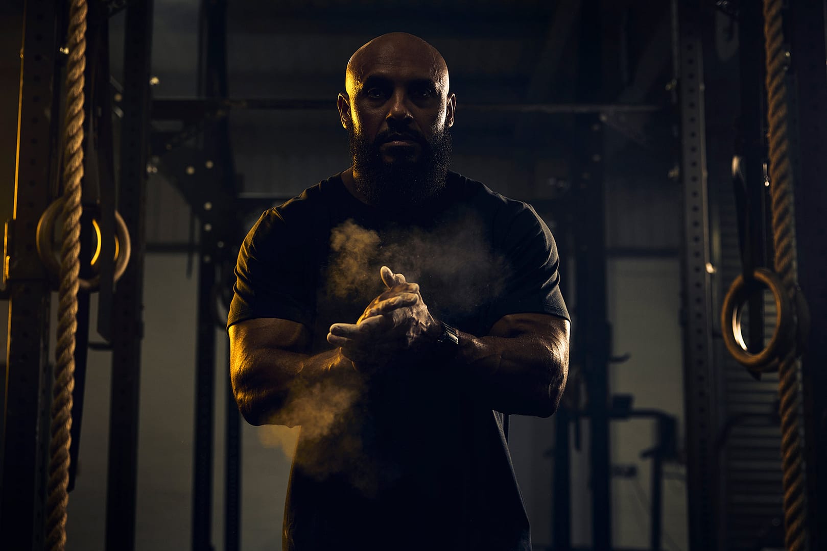 A silhouette of a man with chalk dust in a gym