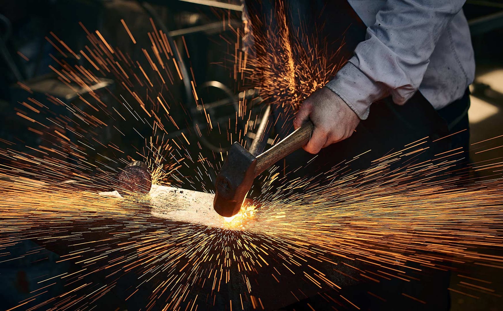 Blacksmith working with a hammer causing sparks to fly everywhere