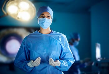A female surgeon wearing scrubs in an operating theatre